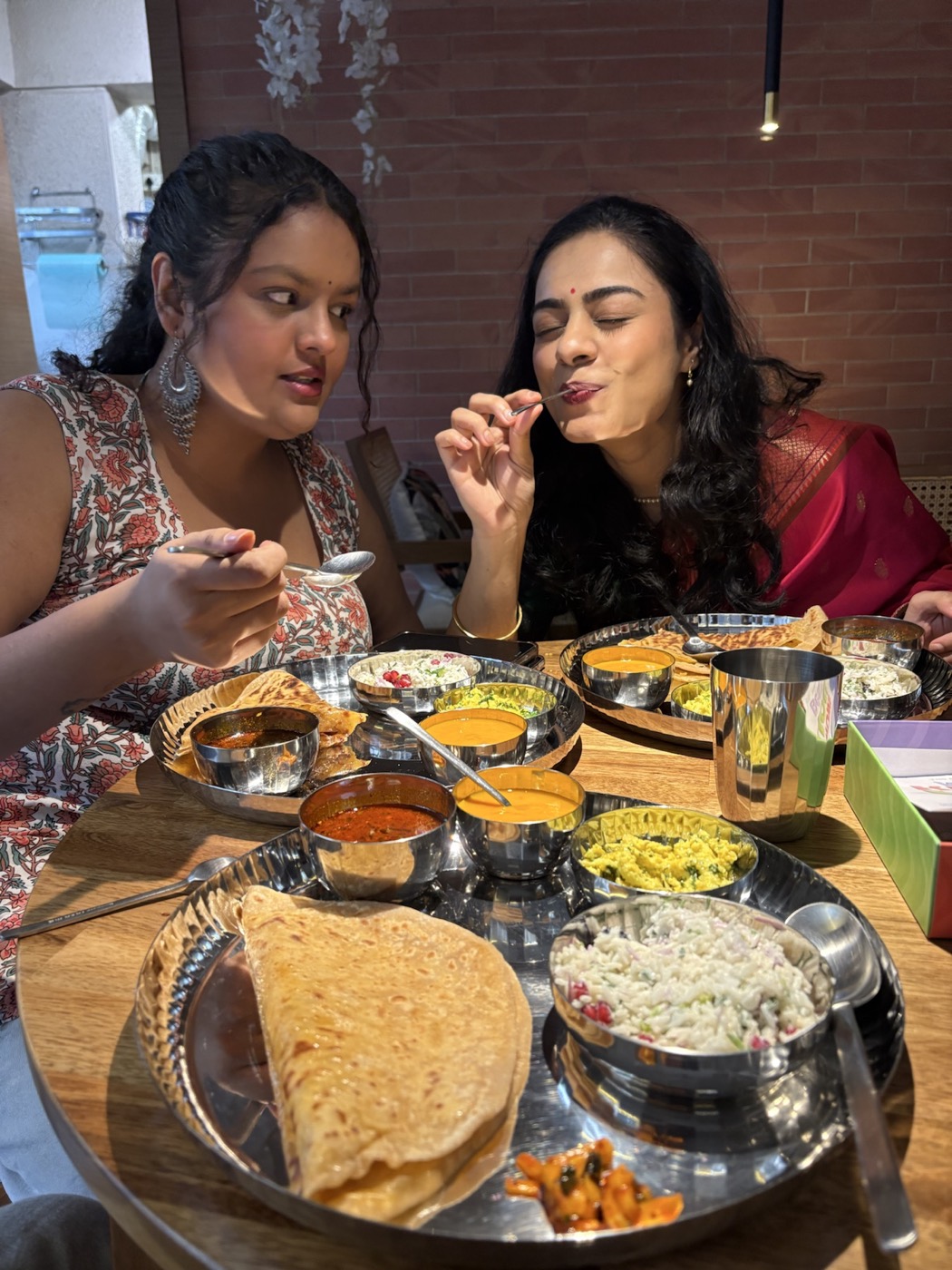 Friends enjoying a thali at the café by OMAH